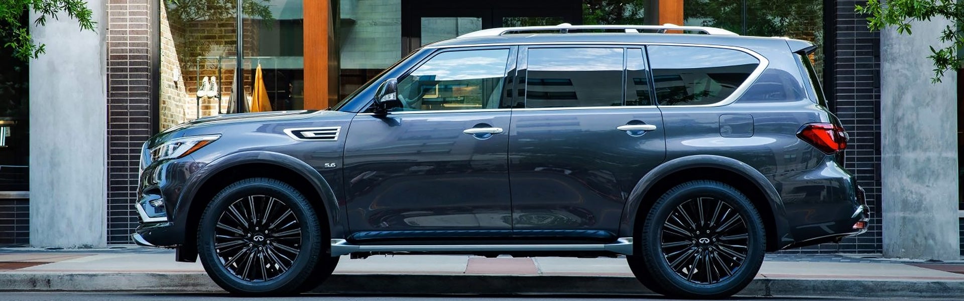 Side view of a grey Infiniti SUV parked on the street.