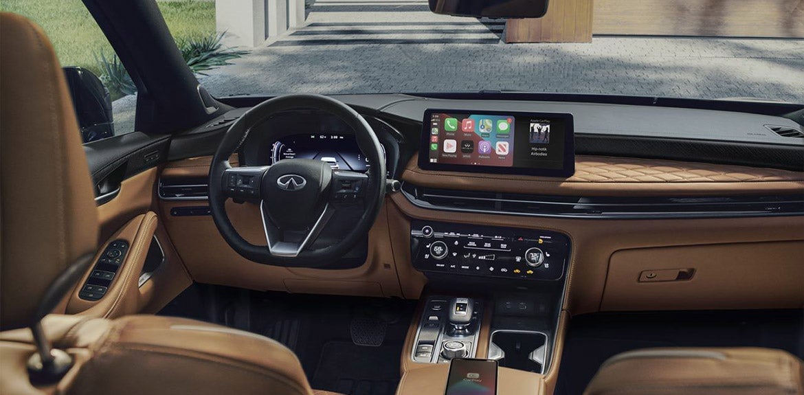 Infiniti QX60 interior featuring a leather-wrapped steering wheel, touchscreen display with smartphone integration.