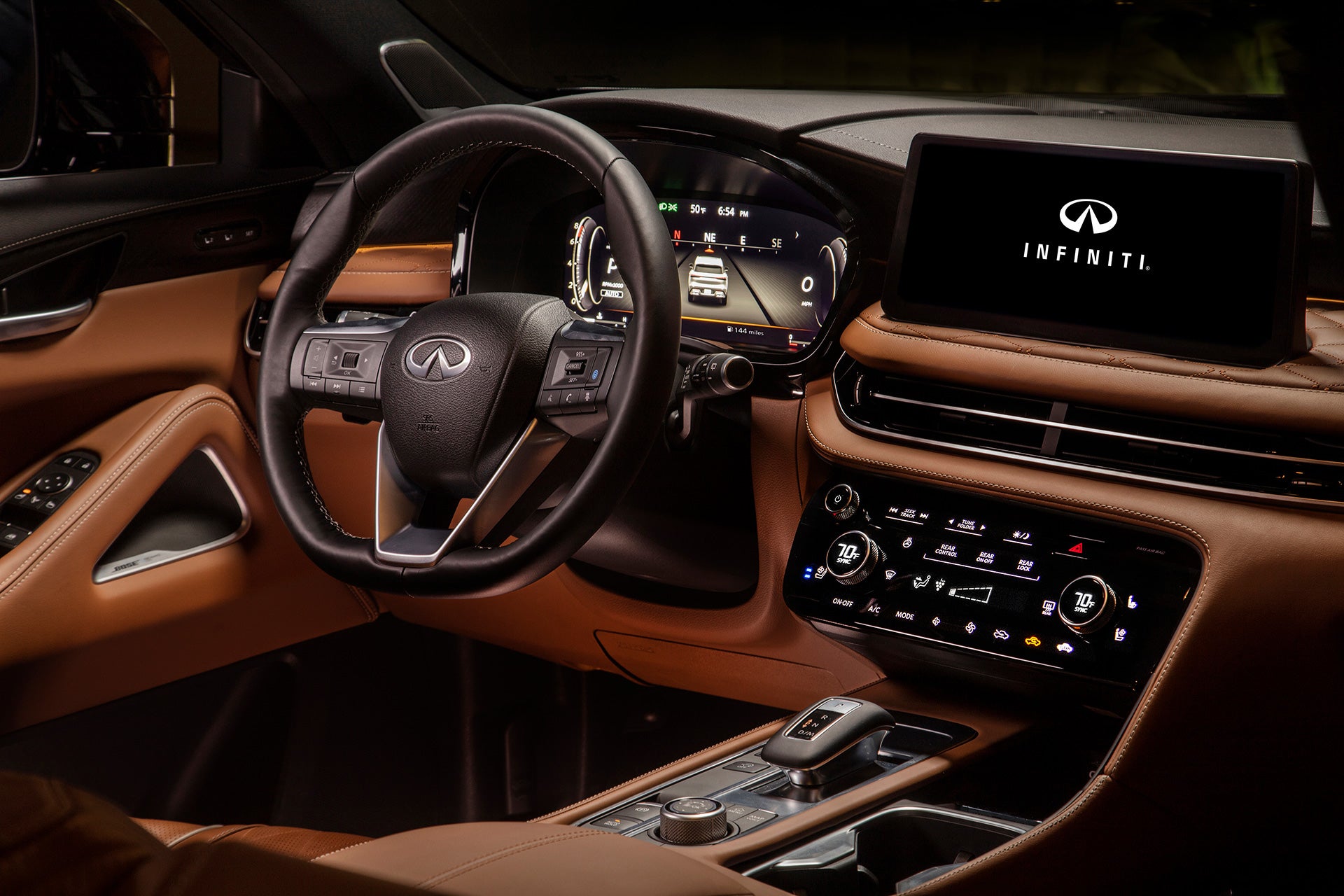 Interior view of the Infiniti QX60 featuring a leather-wrapped steering wheel and central touchscreen display.
